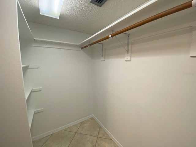 walk in closet featuring light tile patterned flooring