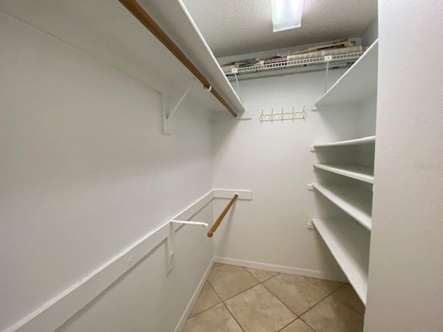 spacious closet with light tile patterned floors