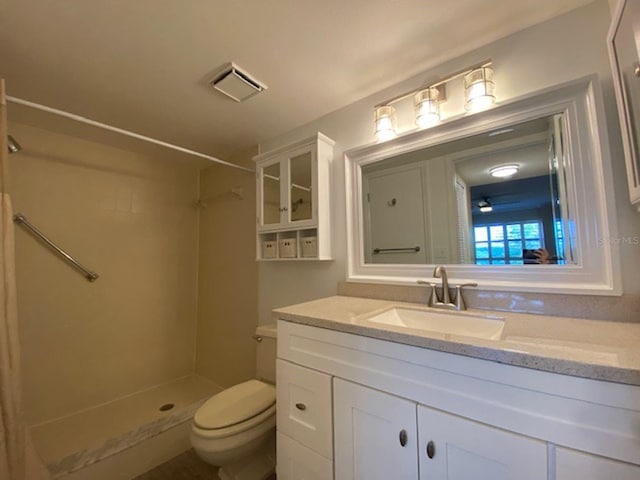 bathroom with toilet, walk in shower, and vanity