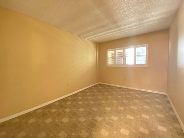 unfurnished room featuring a textured ceiling