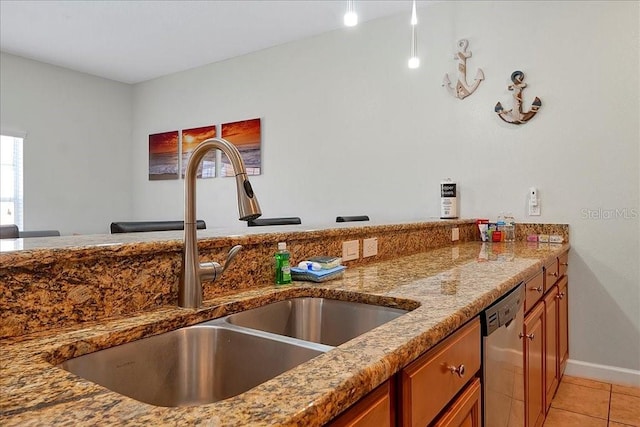 kitchen featuring light tile flooring, light stone countertops, dishwasher, and sink