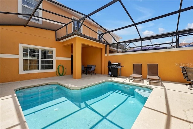 view of pool with area for grilling, a patio, and a lanai