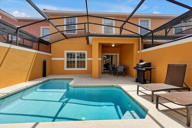 view of swimming pool with a grill, glass enclosure, and a patio area