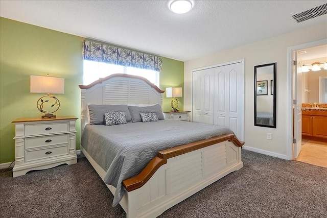 carpeted bedroom with a closet, connected bathroom, and sink