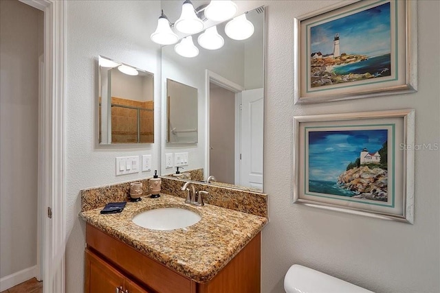 bathroom featuring vanity, a chandelier, and toilet