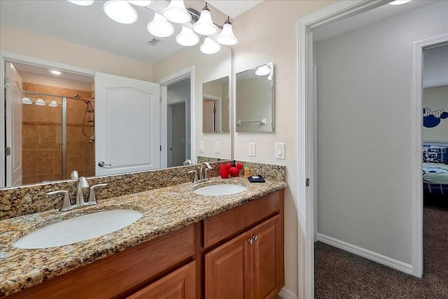 bathroom featuring large vanity, double sink, and a tile shower