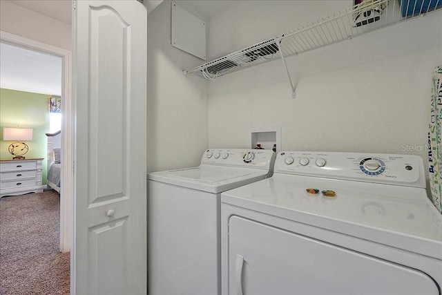 clothes washing area with washing machine and dryer, carpet floors, and hookup for a washing machine