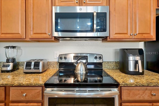 kitchen featuring light stone countertops and stainless steel appliances