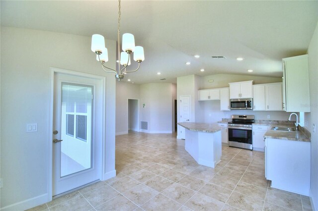 kitchen with white cabinetry, a kitchen island, stainless steel appliances, vaulted ceiling, and sink