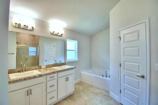 bathroom featuring separate shower and tub, a textured ceiling, tile patterned flooring, and double vanity