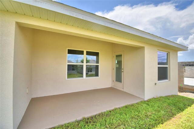 back of house with a patio area and a lawn