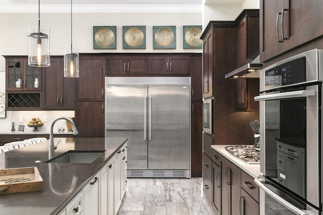 kitchen with decorative light fixtures, stainless steel appliances, crown molding, and sink