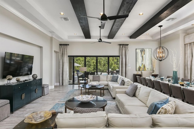 living room with beamed ceiling, ceiling fan with notable chandelier, and light hardwood / wood-style floors