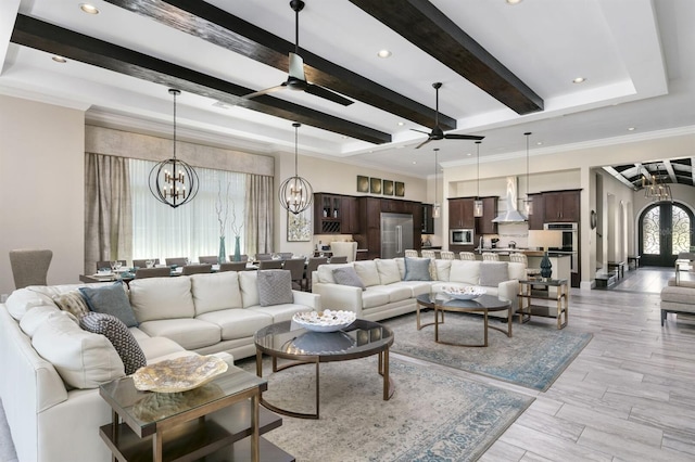 living room with light wood-type flooring, ceiling fan with notable chandelier, crown molding, and beamed ceiling