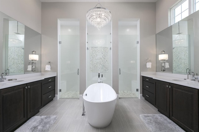 bathroom featuring vanity, plus walk in shower, a chandelier, and tile patterned floors