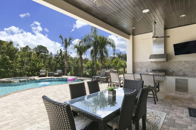 view of patio featuring a grill, exterior kitchen, and a swimming pool with hot tub