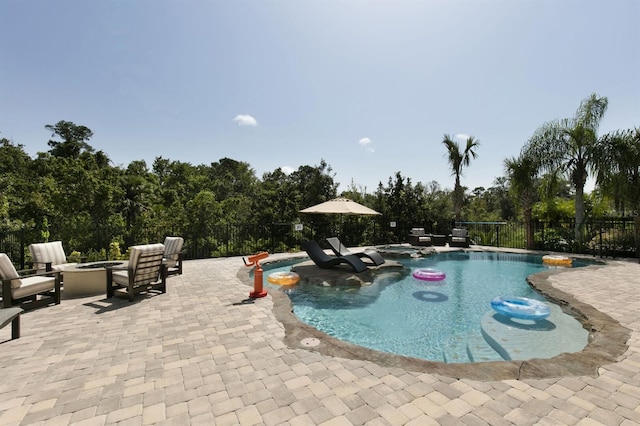 view of swimming pool featuring a hot tub, a patio, and an outdoor fire pit