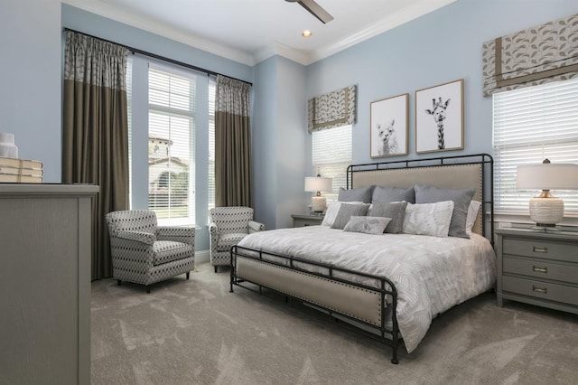 carpeted bedroom with ornamental molding and ceiling fan