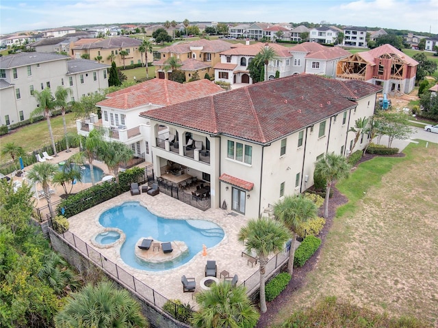 back of house featuring a balcony, a fenced in pool, a patio area, and a fire pit