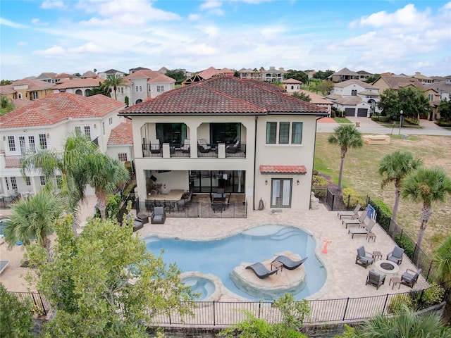 back of property with a balcony, a fenced in pool, and a patio area