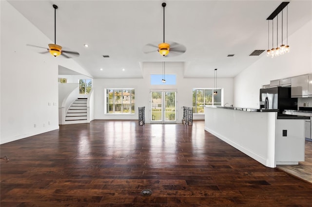 unfurnished living room with french doors, high vaulted ceiling, dark hardwood / wood-style floors, and ceiling fan