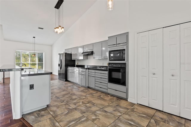 kitchen with pendant lighting, high vaulted ceiling, gray cabinets, black appliances, and dark tile floors