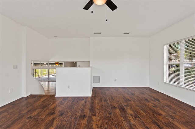 unfurnished living room featuring ceiling fan and dark wood-type flooring