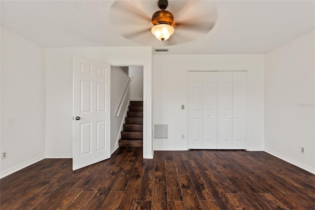 interior space featuring a closet, a textured ceiling, ceiling fan, and dark hardwood / wood-style flooring