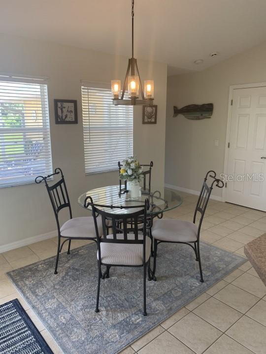 tiled dining room featuring a chandelier