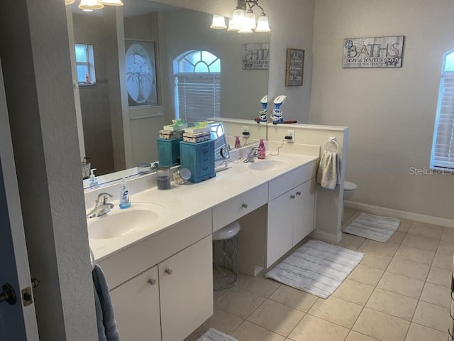 bathroom with toilet, tile floors, and double sink vanity