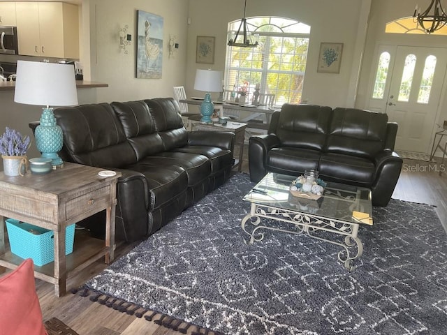 living room featuring an inviting chandelier and dark hardwood / wood-style flooring