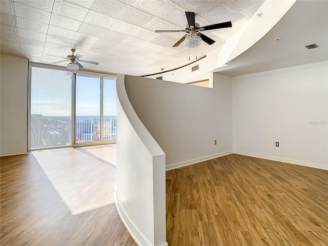 spare room featuring light hardwood / wood-style flooring, floor to ceiling windows, and ceiling fan