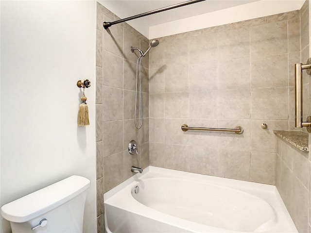 bathroom featuring toilet and tiled shower / bath combo