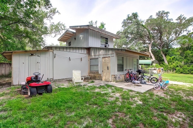 rear view of property with a lawn and a patio area