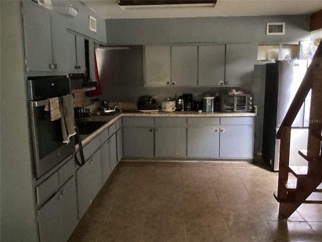 kitchen with light tile floors, refrigerator, and oven