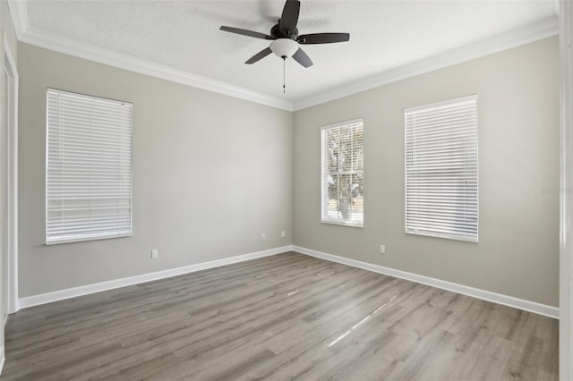 empty room featuring ceiling fan, light wood-type flooring, ornamental molding, and a textured ceiling