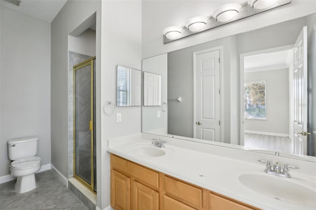 bathroom featuring tile patterned floors, a shower with door, vanity, and toilet