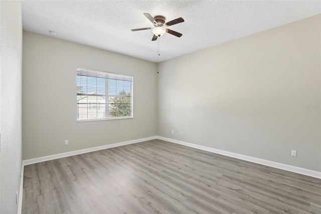 unfurnished room with ceiling fan, light hardwood / wood-style floors, and a textured ceiling