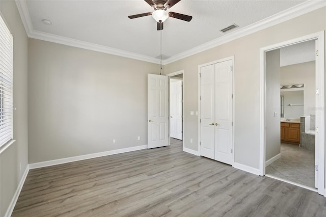 unfurnished bedroom featuring ensuite bath, ceiling fan, light hardwood / wood-style flooring, and crown molding