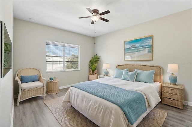 bedroom featuring wood finished floors, a ceiling fan, and baseboards