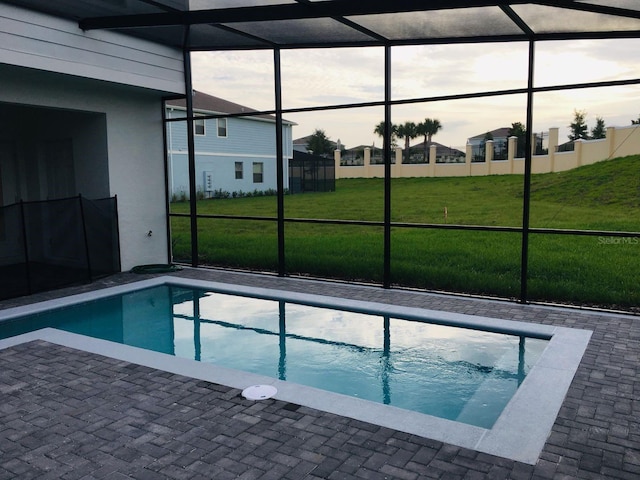 view of pool featuring a patio area, glass enclosure, and a yard