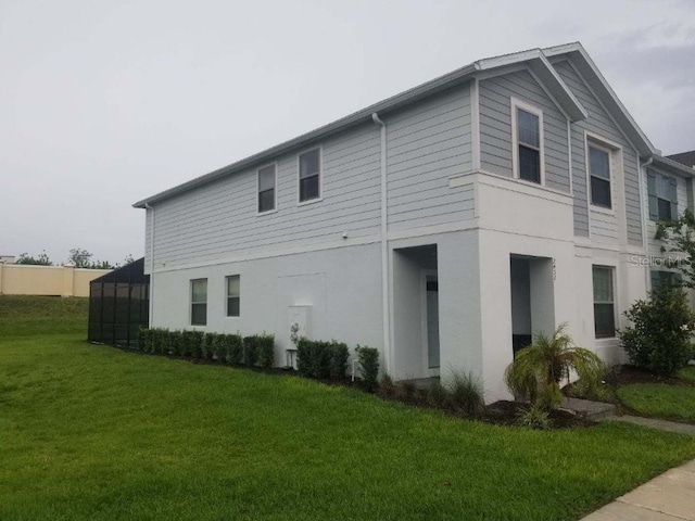 view of side of home with a yard