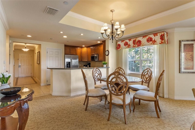 dining room with ornamental molding, a notable chandelier, and light colored carpet