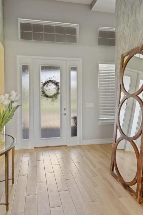 entryway with a high ceiling and light wood-type flooring