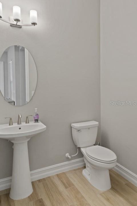 bathroom with hardwood / wood-style flooring, toilet, and sink