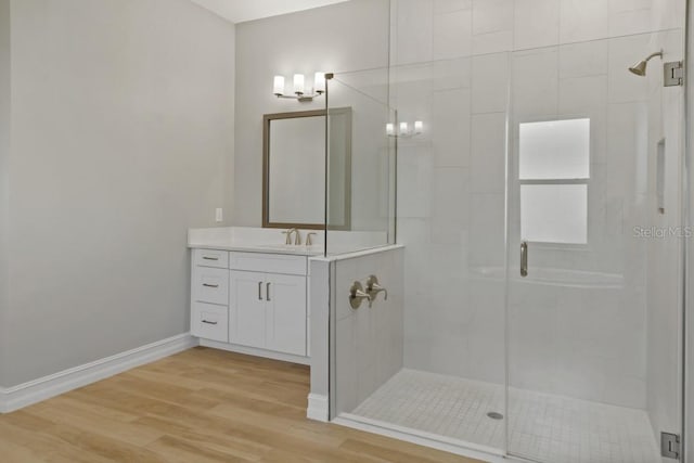 bathroom featuring a shower with door, vanity, and wood-type flooring