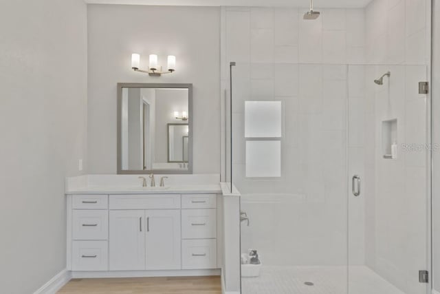 bathroom with vanity, wood-type flooring, and a shower with door