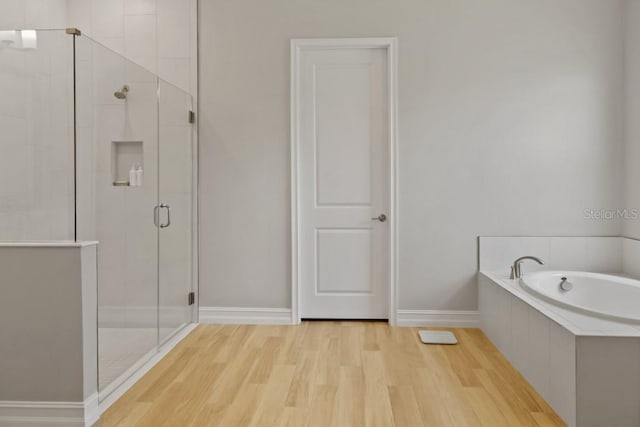 bathroom featuring hardwood / wood-style flooring and shower with separate bathtub