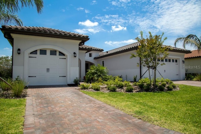 mediterranean / spanish-style home with a front yard and a garage