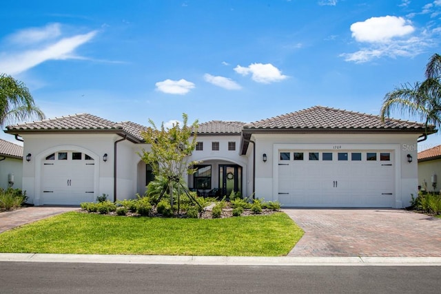 mediterranean / spanish-style home with a front yard and a garage